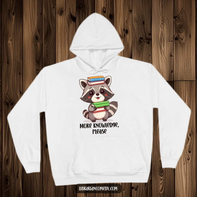 Funny Hoodie: A comical raccoon with a determined look, precariously balancing a stack of colorful books on its head for warmth.